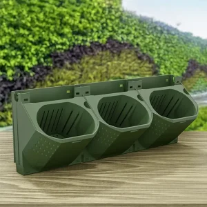 Three green tri-compartment outdoor waste bins mounted on a backplate, set on a wooden surface with a garden background, for sorting garden waste.